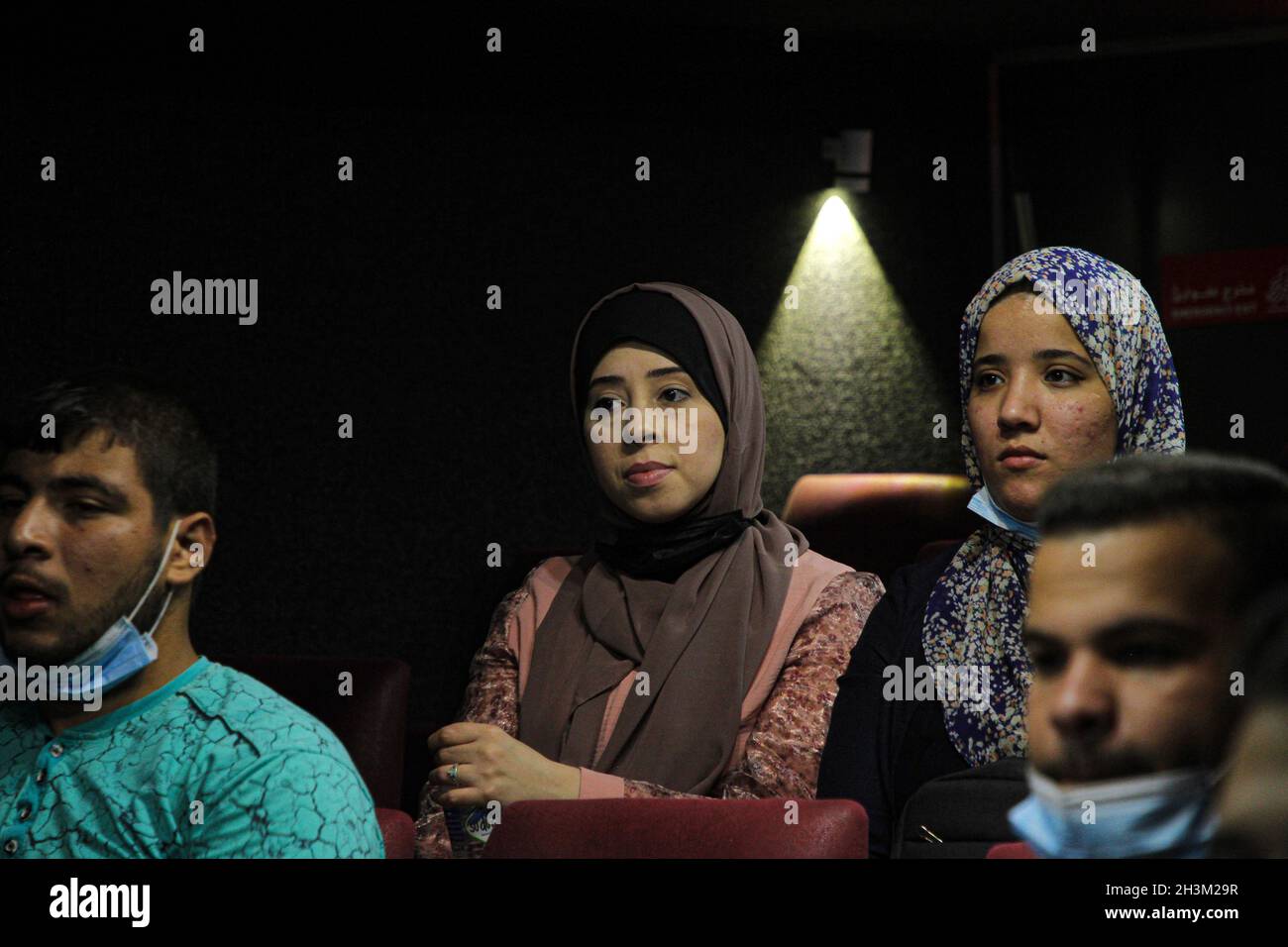 (211029) -- GAZA, 29. Oktober 2021 (Xinhua) -- Palästinenser sehen sich einen Film an, der auf einer weißen Leinwand gezeigt wird, die in einem Bus im nördlichen Gazastreifen aufgestellt ist, am 28. Oktober 2021. ZUM „Feature: Mobiles Kino ermöglicht den Bewohnern, Filme auf einer großen Leinwand in Gaza anzusehen“ (Foto: Rizek Abdeljawad/Xinhua) Stockfoto