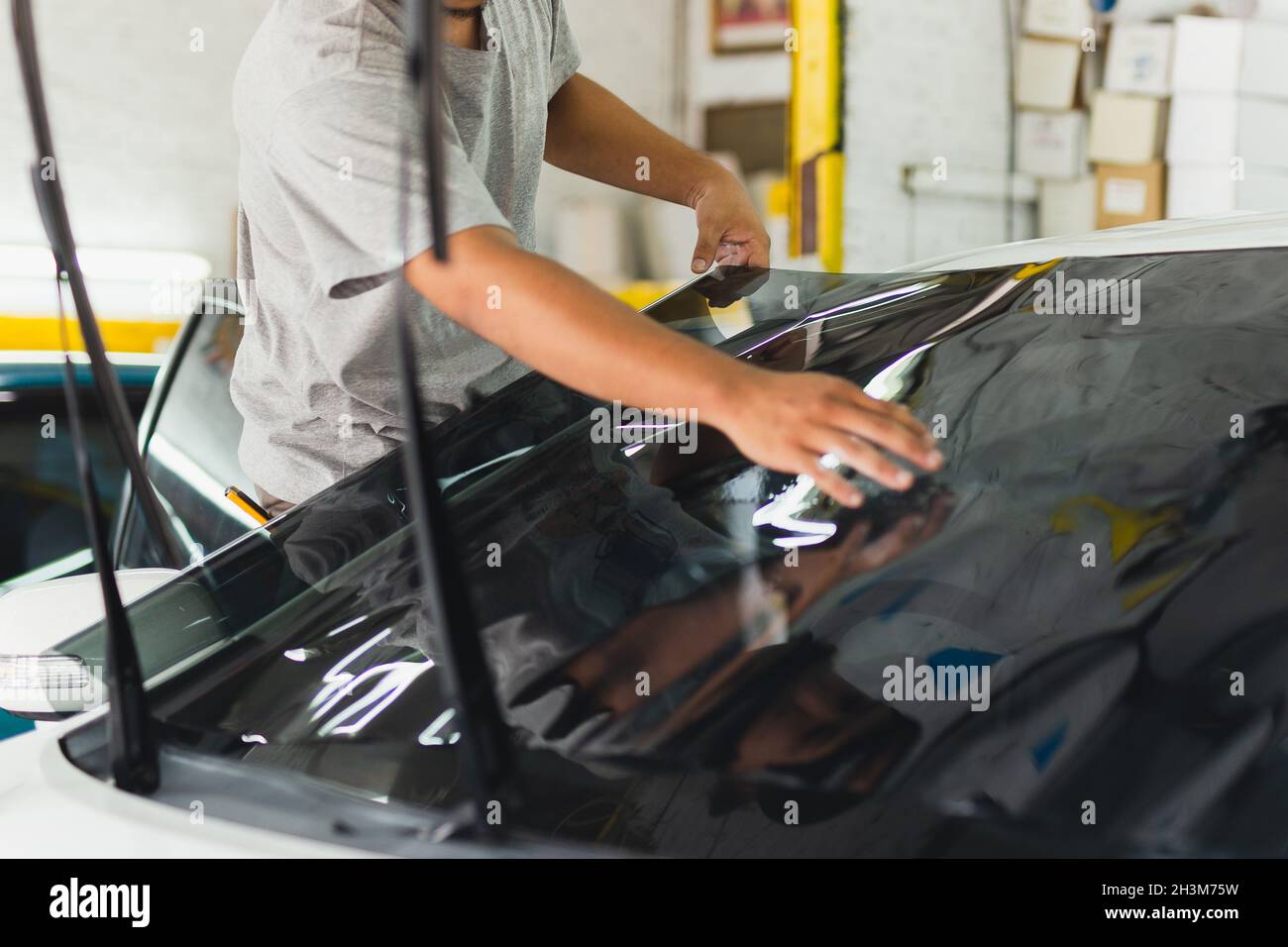 Autospezialist, der im Autoservice Farbfolie auf ein Autofenster aufklebt  Stockfotografie - Alamy