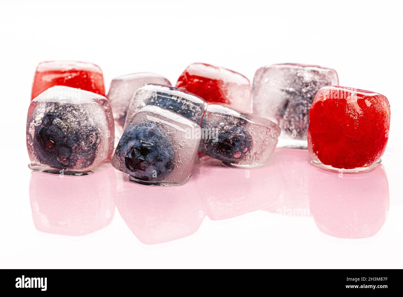 Frische Beeren in Eiswürfeln für Getränke gefroren Stockfoto