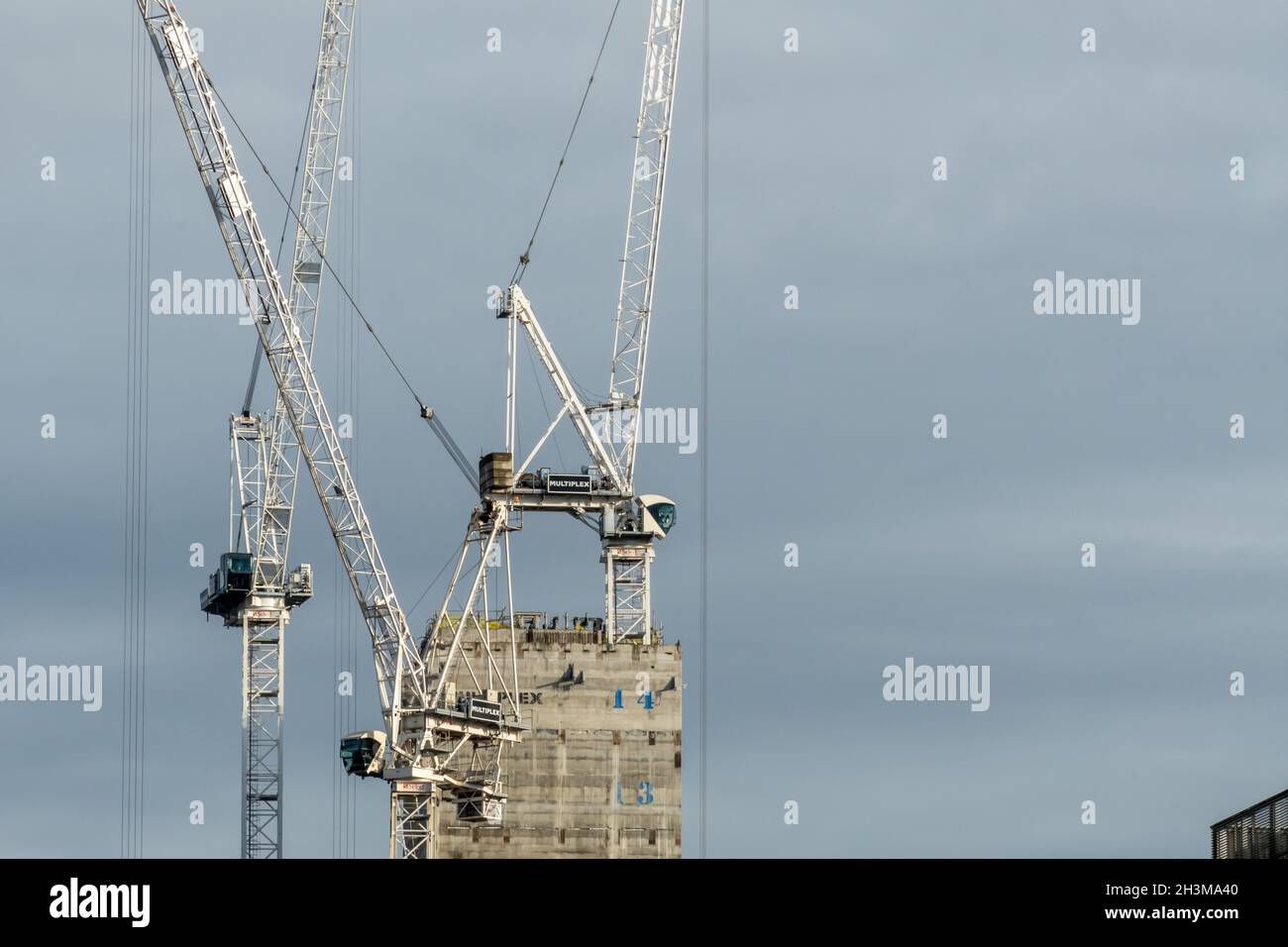 Drei Turmdrehkrane arbeiten am Bau eines hohen Gebäudes im Stadtzentrum von Glasgow. Stockfoto