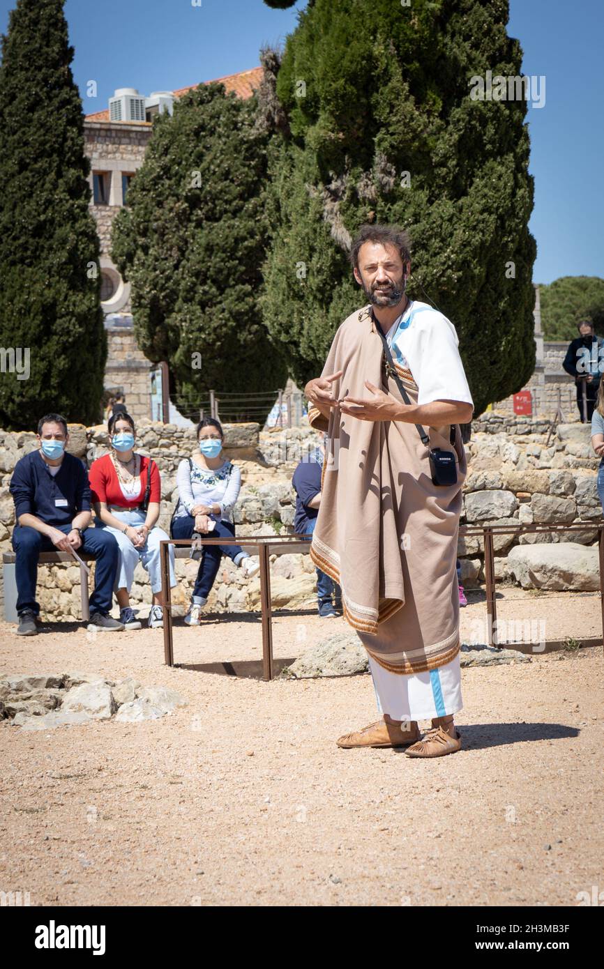 KATALONIEN, SPANIEN-8. MAI 2021: Fremdenführer in authentischer antiker Kleidung bei archäologischen Überresten der antiken Stadt Empuries. Archäologisches Museum von Catal Stockfoto