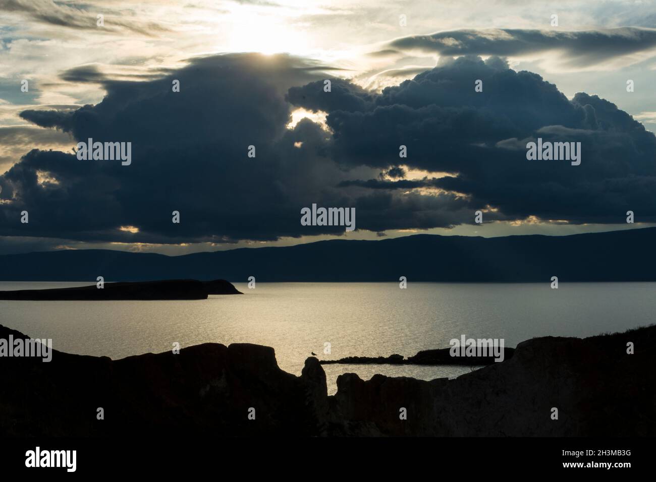 Silhouette einer weit entfernten Möwe am felsigen Ufer am westlichen Ufer der Insel Olchon im Baikalsee. Olchonski Bezirk, Irkutsk Oblast, Russland Stockfoto