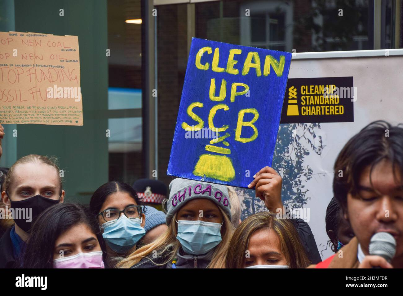 London, Großbritannien. Okt. 2021. Ein Protestler hält ein Plakat mit dem Titel "Clean up SCB (Standard Chartered Bank)" während der Demonstration zur Definanzierung des Klima-Chaos.Aktivisten versammelten sich vor der Klimakonferenz der COP26 vor der Standard Chartered in der City of London und forderten die Bank auf, die Finanzierung fossiler Brennstoffe zu beenden. Kredit: SOPA Images Limited/Alamy Live Nachrichten Stockfoto