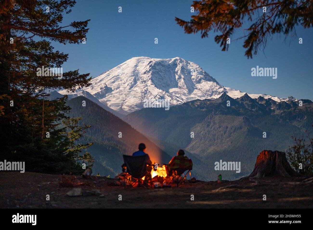 Mit Mount Rainier um das Feuer herum wurden die Camper silhouettiert Stockfoto