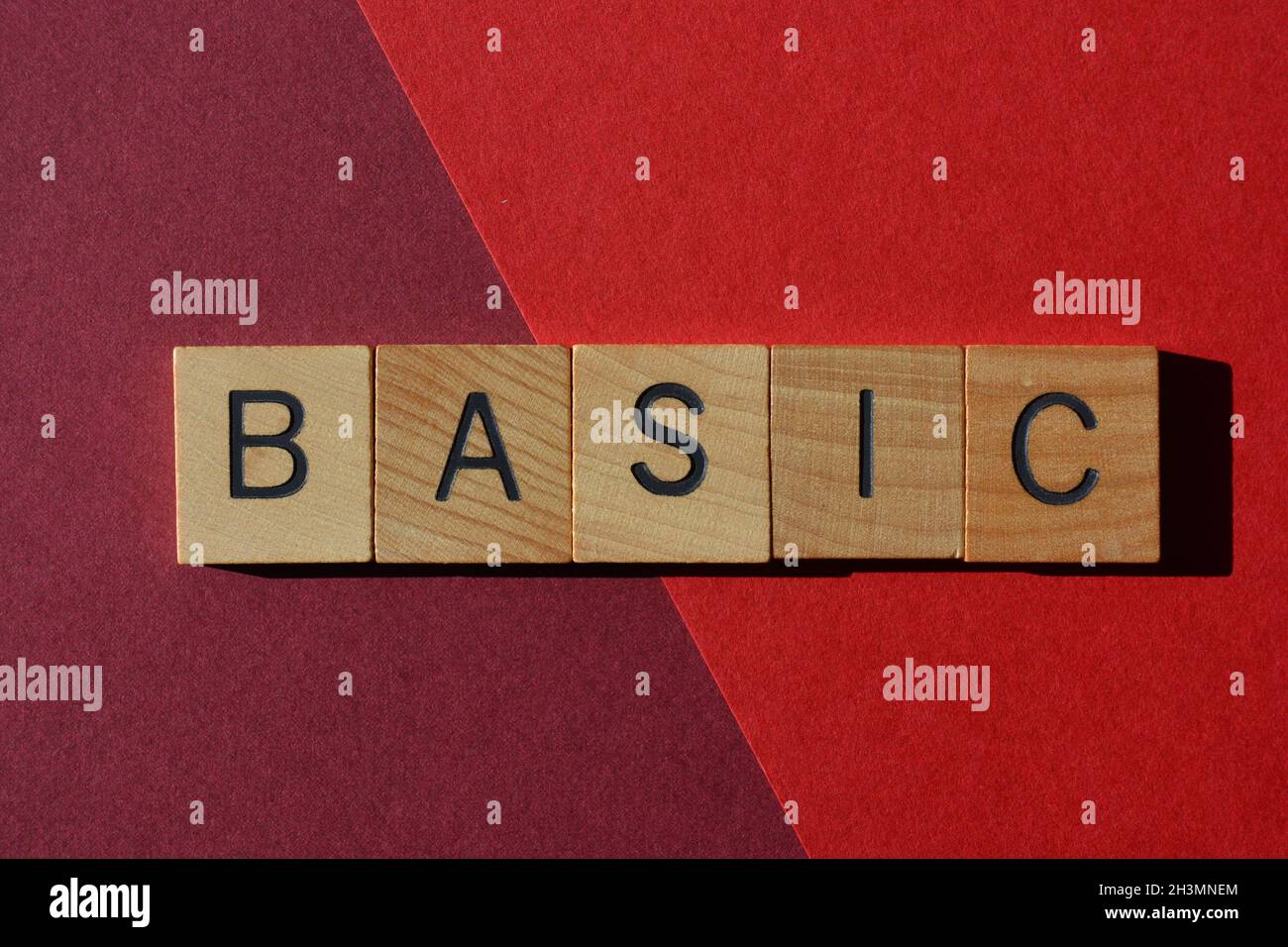 Basic, Wort in Holzbuchstaben auf rotem Hintergrund isoliert Stockfoto