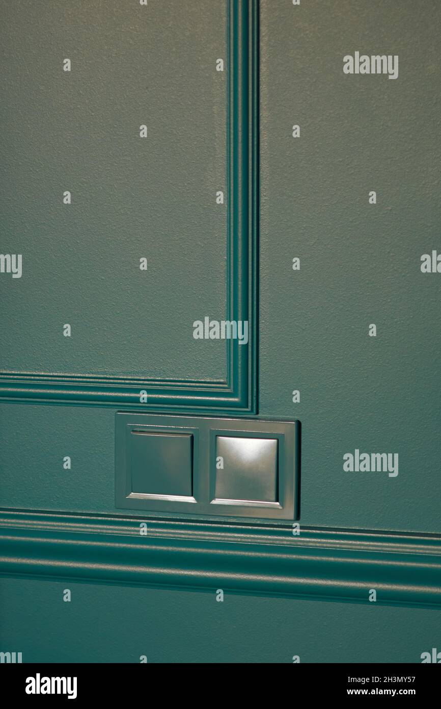 Marineblaue Schalter für Elektrohaushalte in minimalistischer Innenarchitektur. Stilvoller Türgriff für Schlafzimmer und Wohnzimmer. Zimmer mit Holzparkett. Innenraum Stockfoto