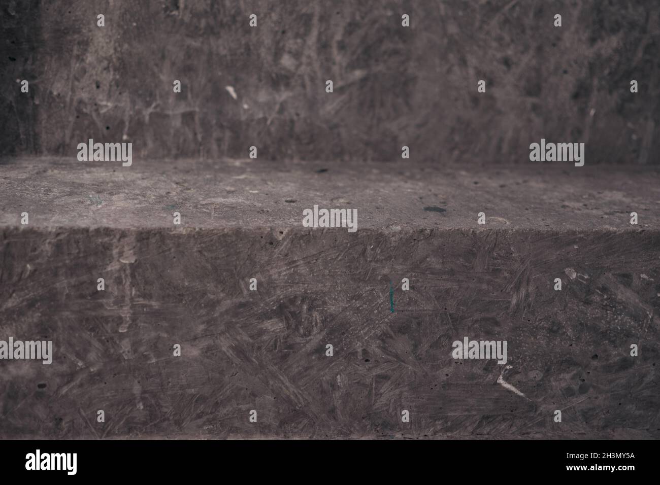 Nahaufnahme der Treppe auf schwarzem Stein Wand Eckhintergrund. Schwarze Lobby-Innentreppe aus rauem Beton mit schwarzem Stahlgeländer. Minimalistisch Stockfoto