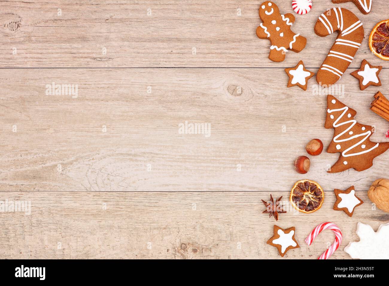 Weihnachts-Lebkuchen, Süßigkeiten und Backwaren. Seitenrand mit Blick von oben auf einem Holzhintergrund. Stockfoto