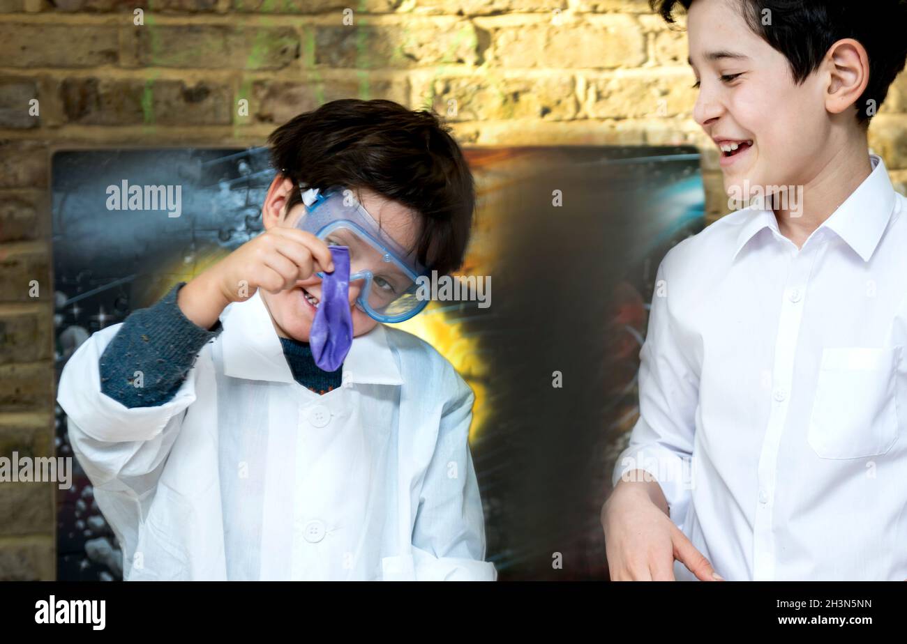 Großbritannien, Jungen (4-5, 10-11) machen wissenschaftliche Experimente zu Hause Stockfoto