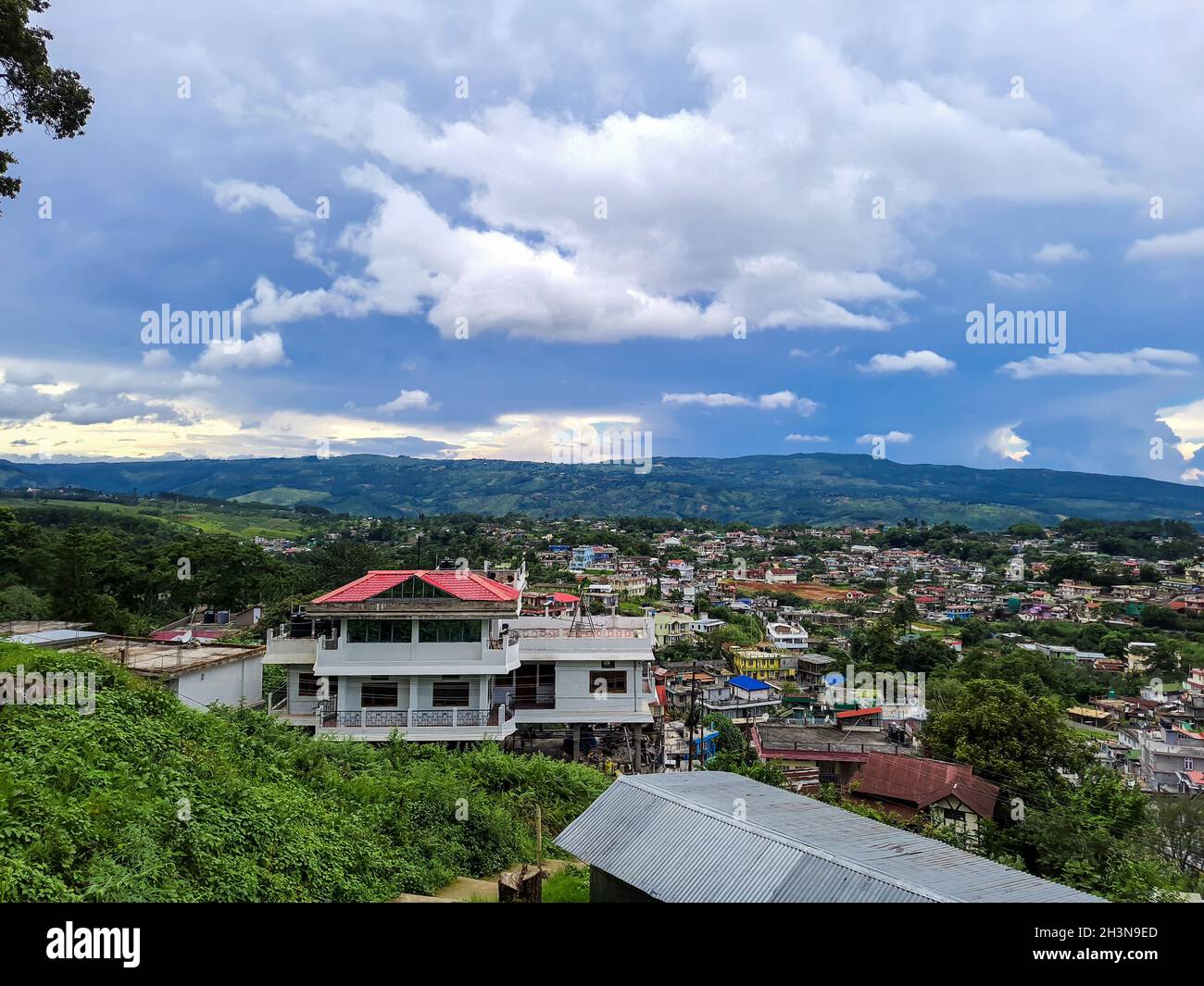Blick auf die Urbanisierung der Stadt mit Bergkette im Hintergrund am Morgen aus flachem Winkel Stockfoto