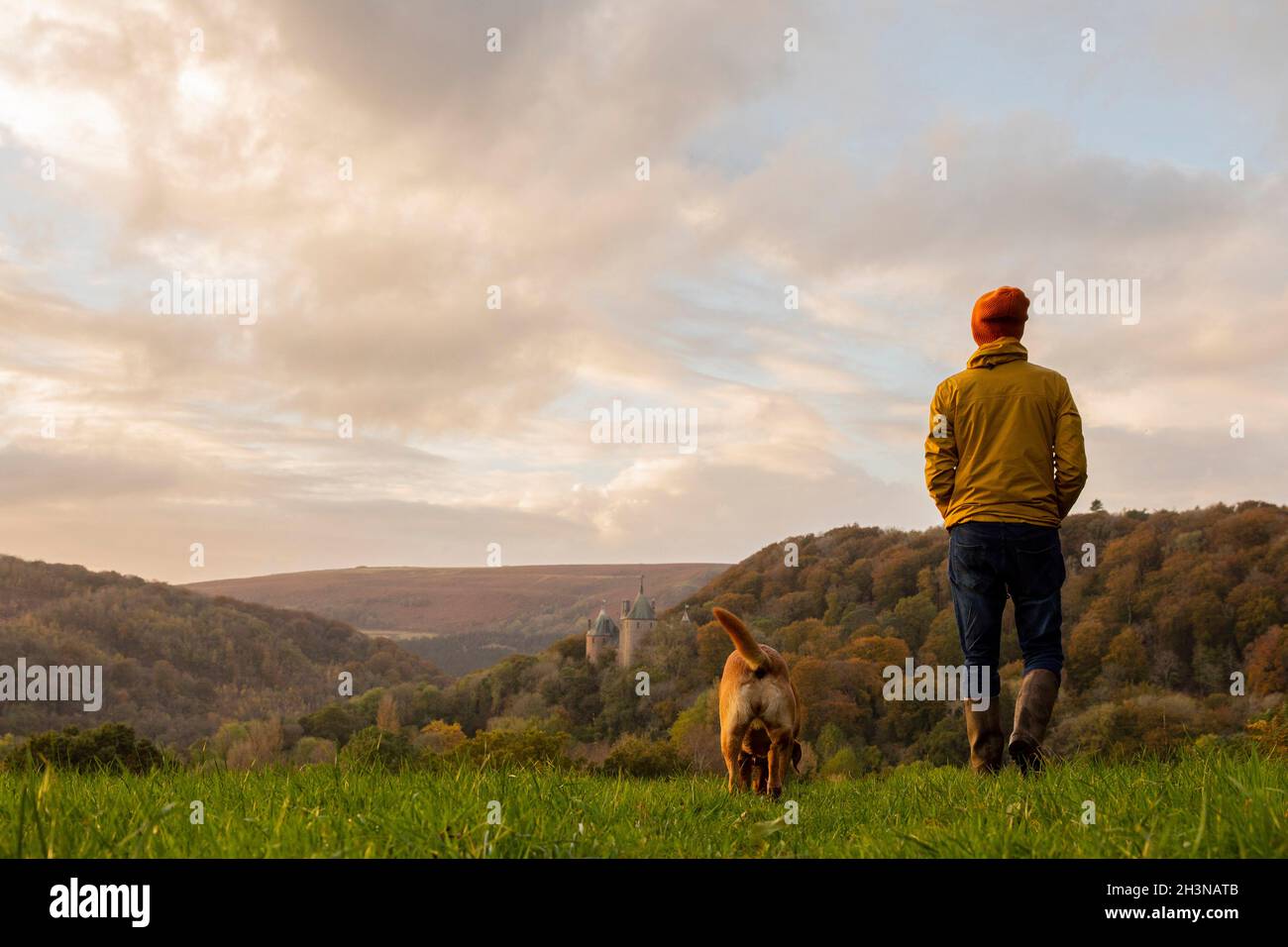 Cardiff, Wales, Großbritannien. Okt. 2021. Ein Mann und ein Hund spazieren in der Nähe von Castell Coch in Cardiff, während die Herbstfarben des Waldes während des unruhigen Wetters aufscheinen. Kredit: Mark Hawkins/Alamy Live Nachrichten Stockfoto