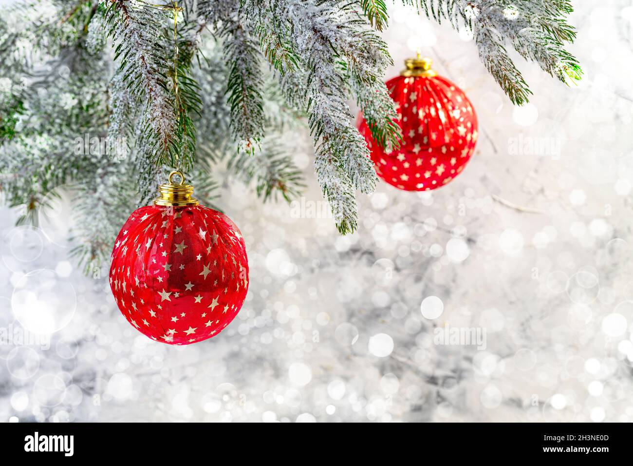 Weihnachtskarte mit roten Kugeln auf einem Fichtenzweig. Stockfoto