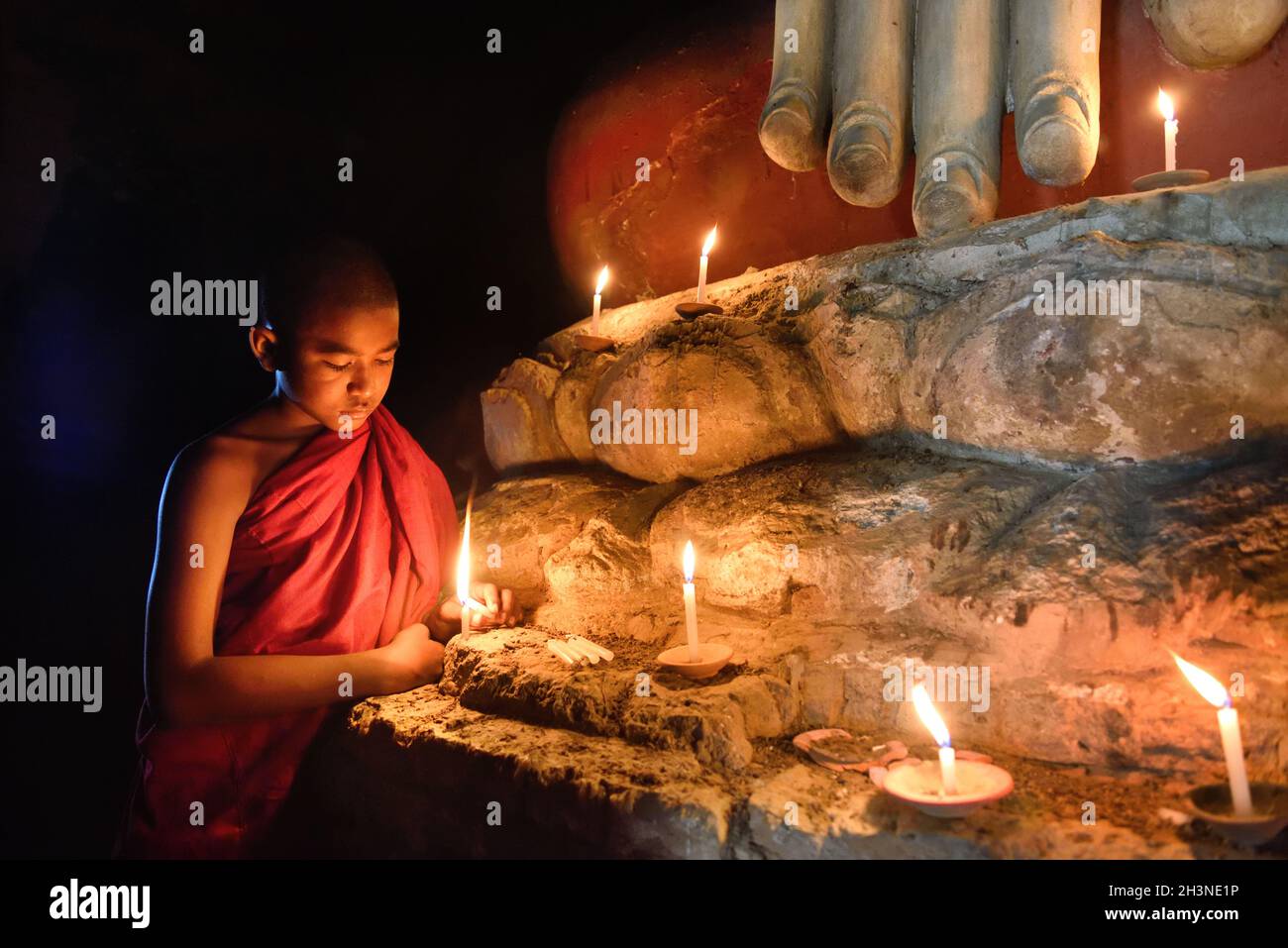 Bagan, Myanmar - Dezember 8: Junger buddhistischer Mönch betet mit Kerzen in der Nähe der Buddha-Statue im alten Pagodentempel im mandalay historischen Park. Desembe Stockfoto