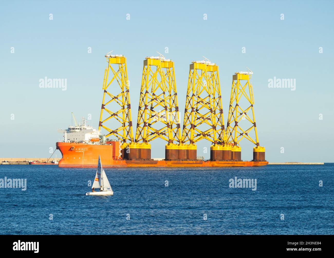 Gran Canaria, Kanarische Inseln, Spanien. Oktober 2021. Das Schwerlastschiff Fan Zhou 10 überragt Schiffe und Sportboote, während es in Las Palmas auf Gran Canaria zum Tanken anhält. Das Schiff ist unterwegs von China nach Nigg im Cromarty Firth, Schottland. Die sechs Windturbinen-Jacken oder -Basen werden vor der Küste von Angus an dem nach Fertigstellung größten Offshore-Windpark Schottlands installiert. Quelle: Alan Dawson/Alamy Live News. Stockfoto