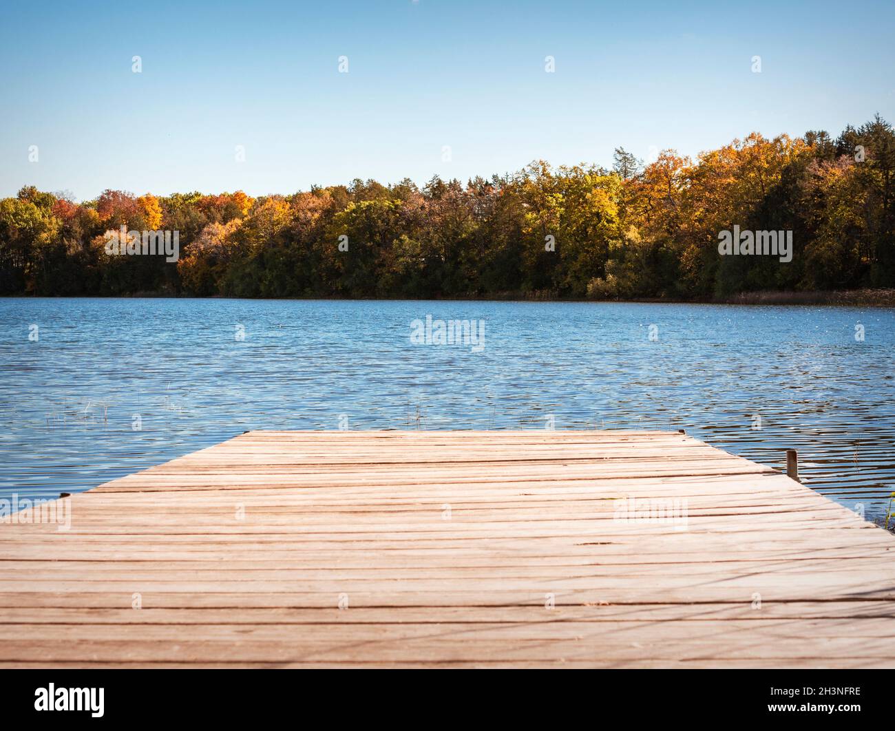 Ein Pier an einem Waukesha County Lake in Wisconsin an einem sonnigen Herbsttag. Stockfoto
