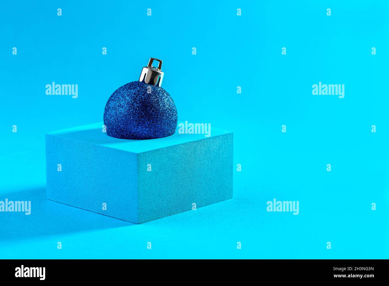 Abstrakte Weihnachtskarte mit einem glänzenden blauen Ball. Stockfoto