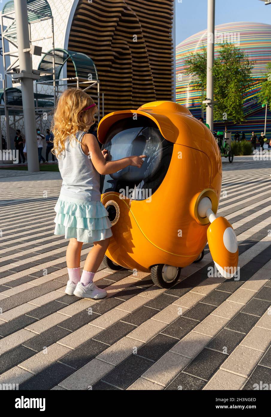 Dubai, VAE - 10.16.2021 Aufnahme eines kleinen Mädchens, das mit einem niedlichen kleinen Roboter an der EXPO 2020 spielt. Stockfoto