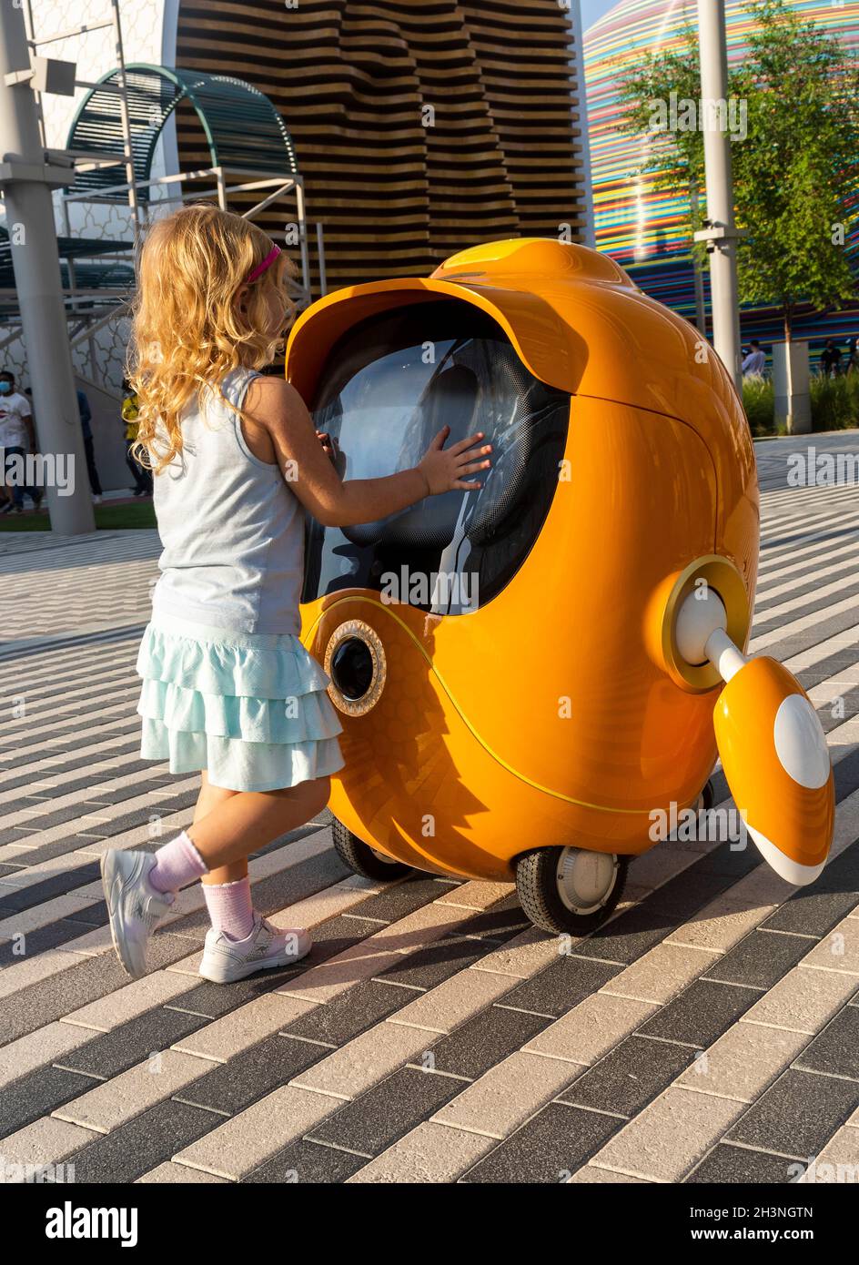 Dubai, VAE - 10.16.2021 Aufnahme eines kleinen Mädchens, das mit einem niedlichen kleinen Roboter an der EXPO 2020 spielt. Stockfoto