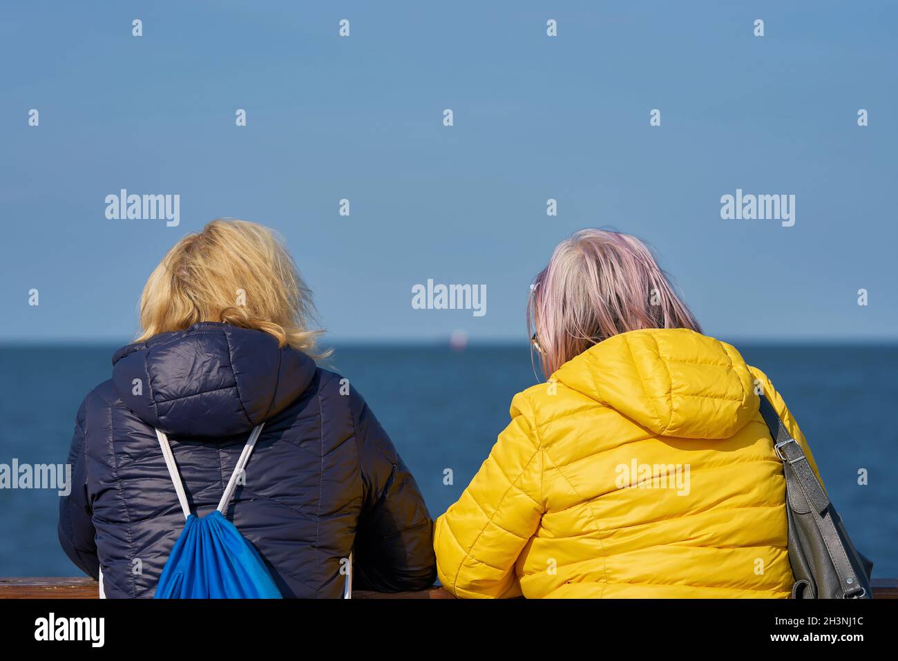 Zwei Frauen während eines Gesprächs an einem Brückengeländer Stockfoto