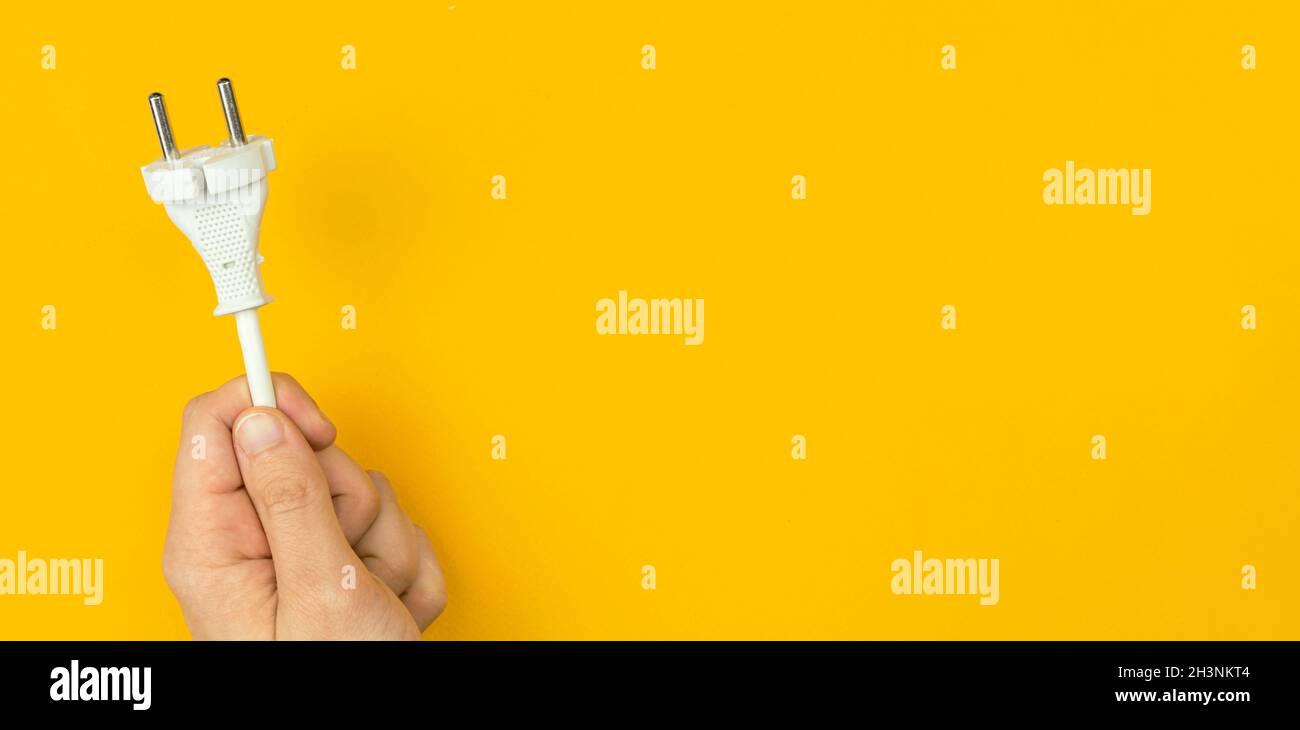 Stromkabel in der Hand, Banner. Orangefarbener Hintergrund, flaches Lay, Draufsicht und Kopierbereich Stockfoto