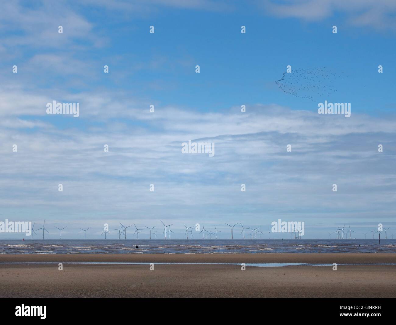 Der Strand von blundell Sands in sefton bei southport mit Wellenbrechern am Strand und den Windturbinen am burbo-Ufer sichtbar Stockfoto