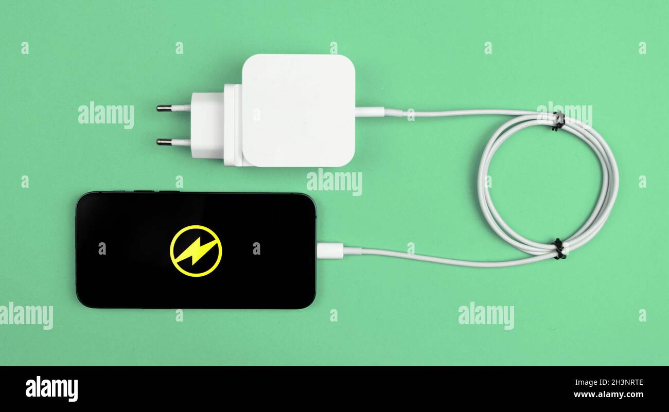 Ladekabel für Mobiltelefon. Moderner Ladeadapter für Smartphone. Minze Hintergrund, flach Lay und Draufsicht Stockfoto