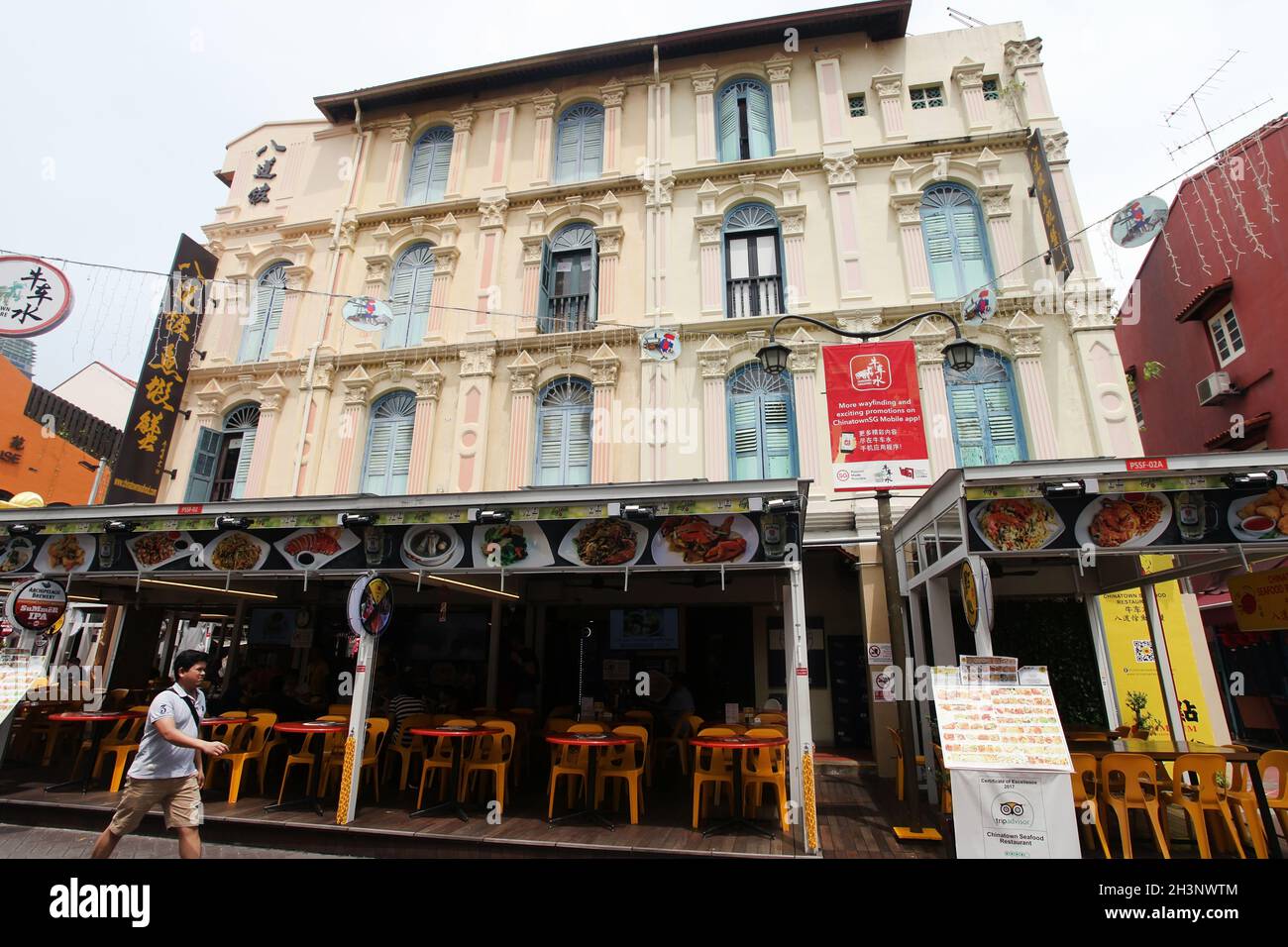 Eine Person, die an einem Restaurant in einem alten Geschäftshaus in der Pagoda Street in Singapurs Chinatown vorbeigeht. Stockfoto