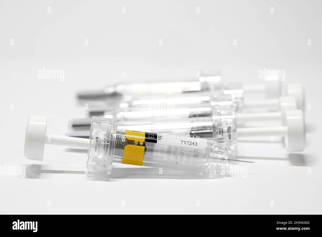 Spritze mit Impfstoff gegen Coronavirus auf einem Tisch Stockfoto