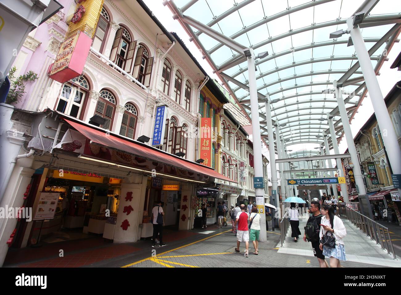 Die North Bridge Road, Ende der Pagoda Street mit überdachtem Gehweg, Geschäften und Restaurants und mit mehreren Leuten, die in Singapurs Chinatown spazieren. Stockfoto