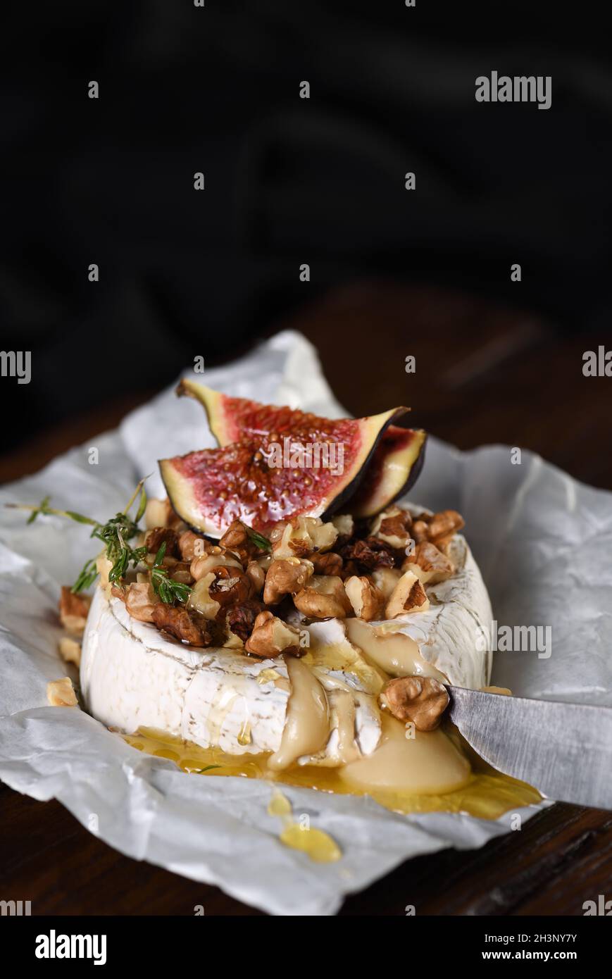 Gebackener Camembert mit Nüssen und Honig, Feigen- und Thymianscheiben. Stockfoto