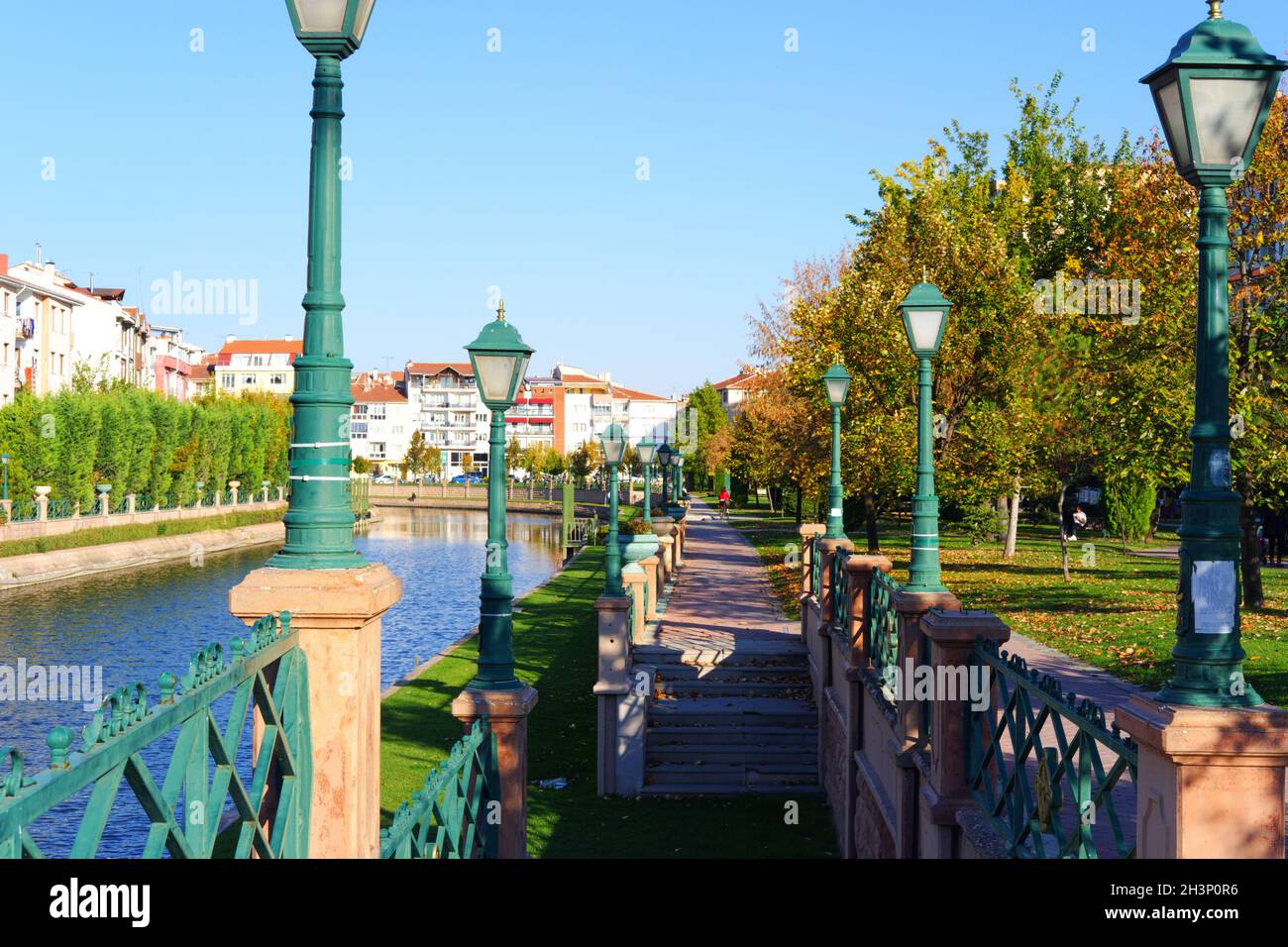 Treppen, grüne dekorative Straßenlampen und Bäume in einem Park am Straßenrand in Eskisehir Stockfoto