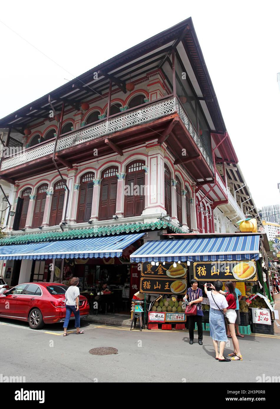 Kreuzungspunkt zwischen Temple Street und Trengganu Street mit alten Ladenhäusern, Geschäften und Ständen und Menschen, die in Singapurs Chinatown spazieren. Stockfoto