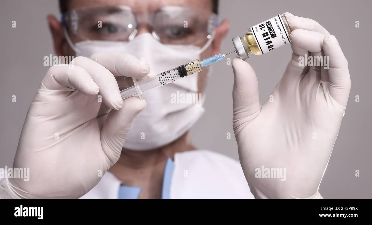 COVID-19. Arzt Wissenschaftler sammelt den Impfstoff, um den Patienten zu impfen. Männlicher Forscher testen Impfstoff im Labor. Stockfoto