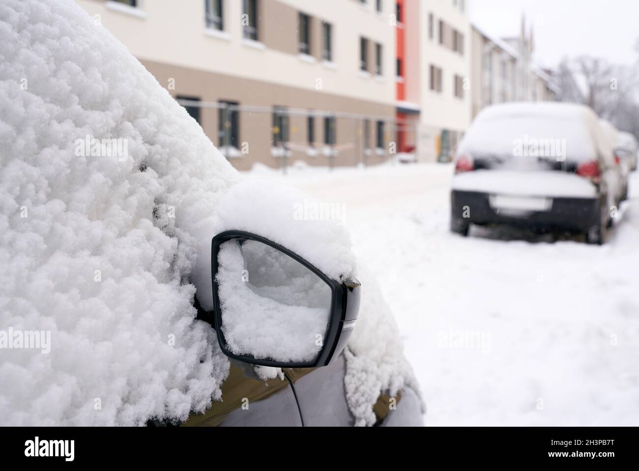 Eingeschneite Autos in einer Straße im Stadtzentrum von Magdeburg in Deutschland im Winter Stockfoto