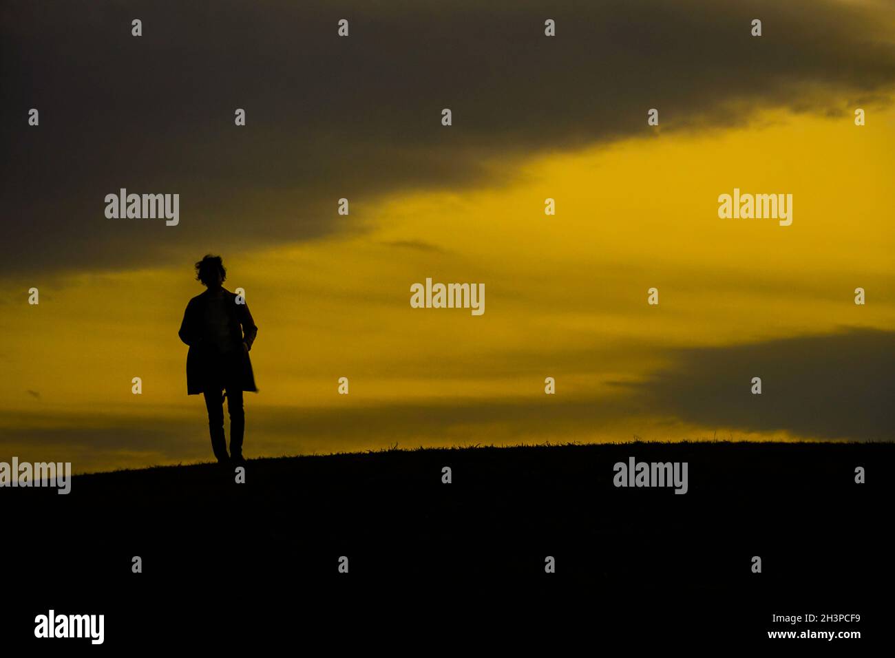 Männer Silhouette steht auf einem Hügel Stockfoto