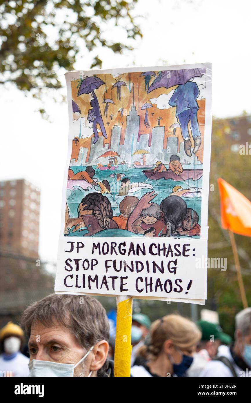 New York, USA. Okt. 2021. Ein Demonstrator hält ein Plakat mit der Aufschrift „JP Morgan Chase: Stop Funding Climate Chaos!“ Während der Demonstration marschierten Umweltaktivisten am neunten Jahrestag des Hurrikan Sandy von der Brooklyn Bridge zur Federal Reserve und dann zum Hauptquartier der Citibank, um die Veräußerung fossiler Brennstoffe zu fordern. Nach der Disco-Bedienz in der Citibank hielten sie einen kurzen Einfall ab. Kredit: SOPA Images Limited/Alamy Live Nachrichten Stockfoto