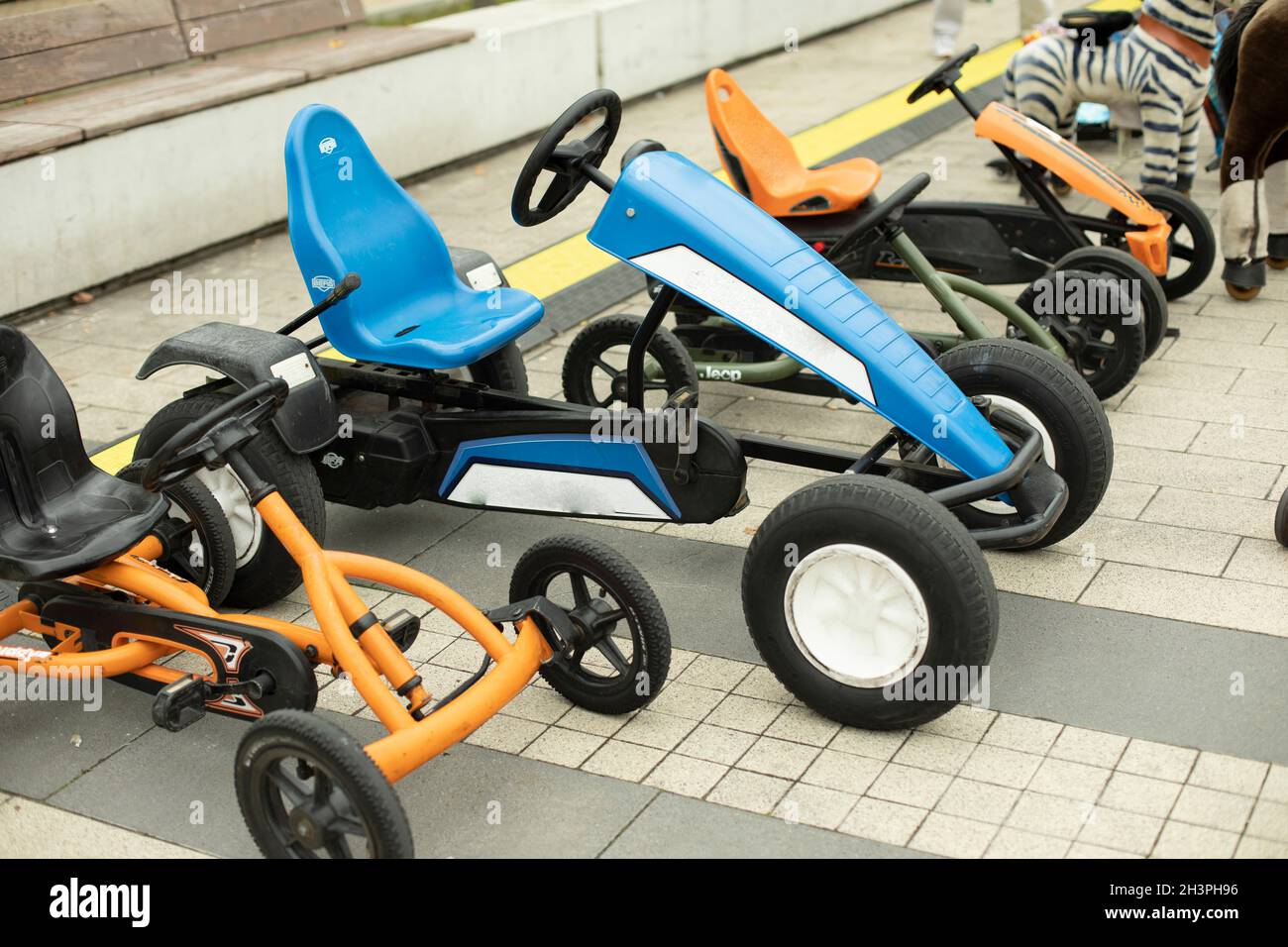 Kindertransport im Park. Maschinen auf mechanischem Kurs. Unterhaltsame Fahrräder können gemietet werden. Roller für Vorschulkinder. Stockfoto