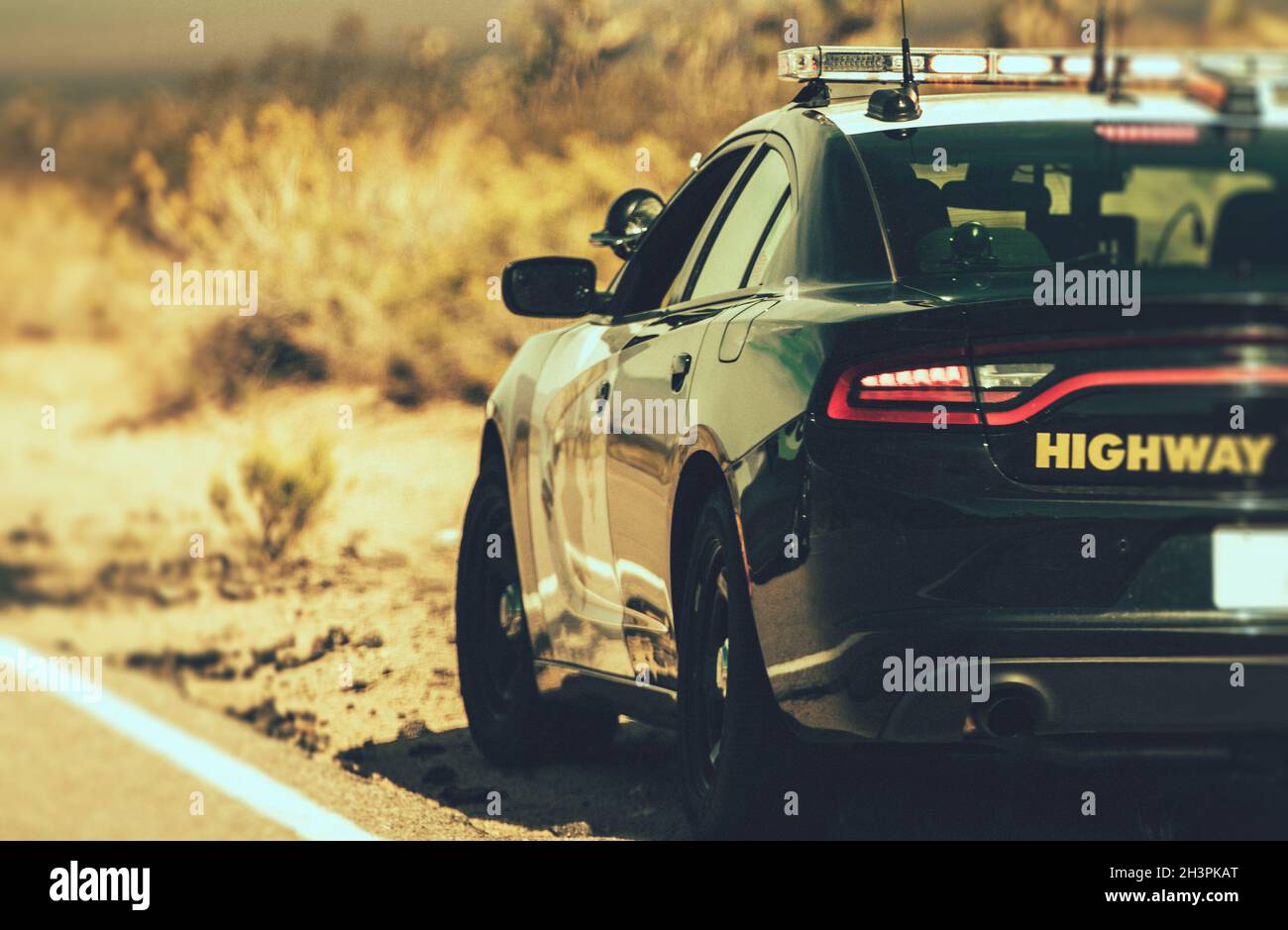 California Highway Patrol Cruiser auf der Seite eines Desert Highway. Vereinigte Staaten von Amerika. Polizei-Thema. Stockfoto