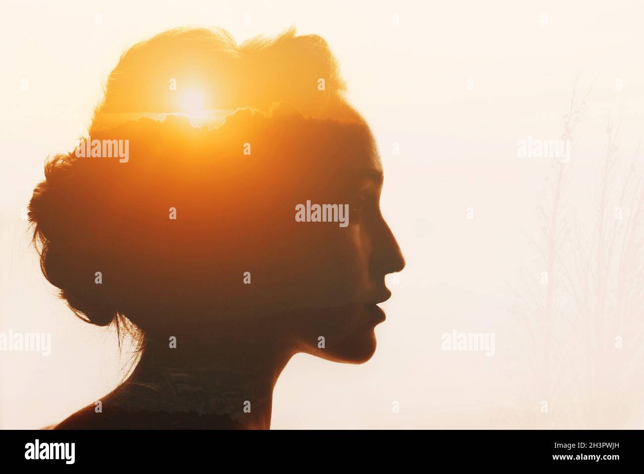 Frau mit Sonnenuntergang und Wolken über ihrem Kopf. Selbstzurückhaltung und Selbstverbesserungskonzept Stockfoto