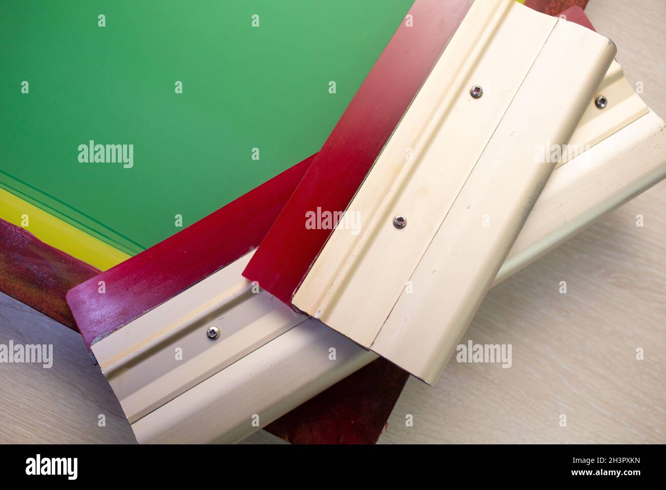 Siebdruck-Verfahren für Siebdruck in der Bekleidungsfabrik. Rahmenschablone und Rakel Stockfoto