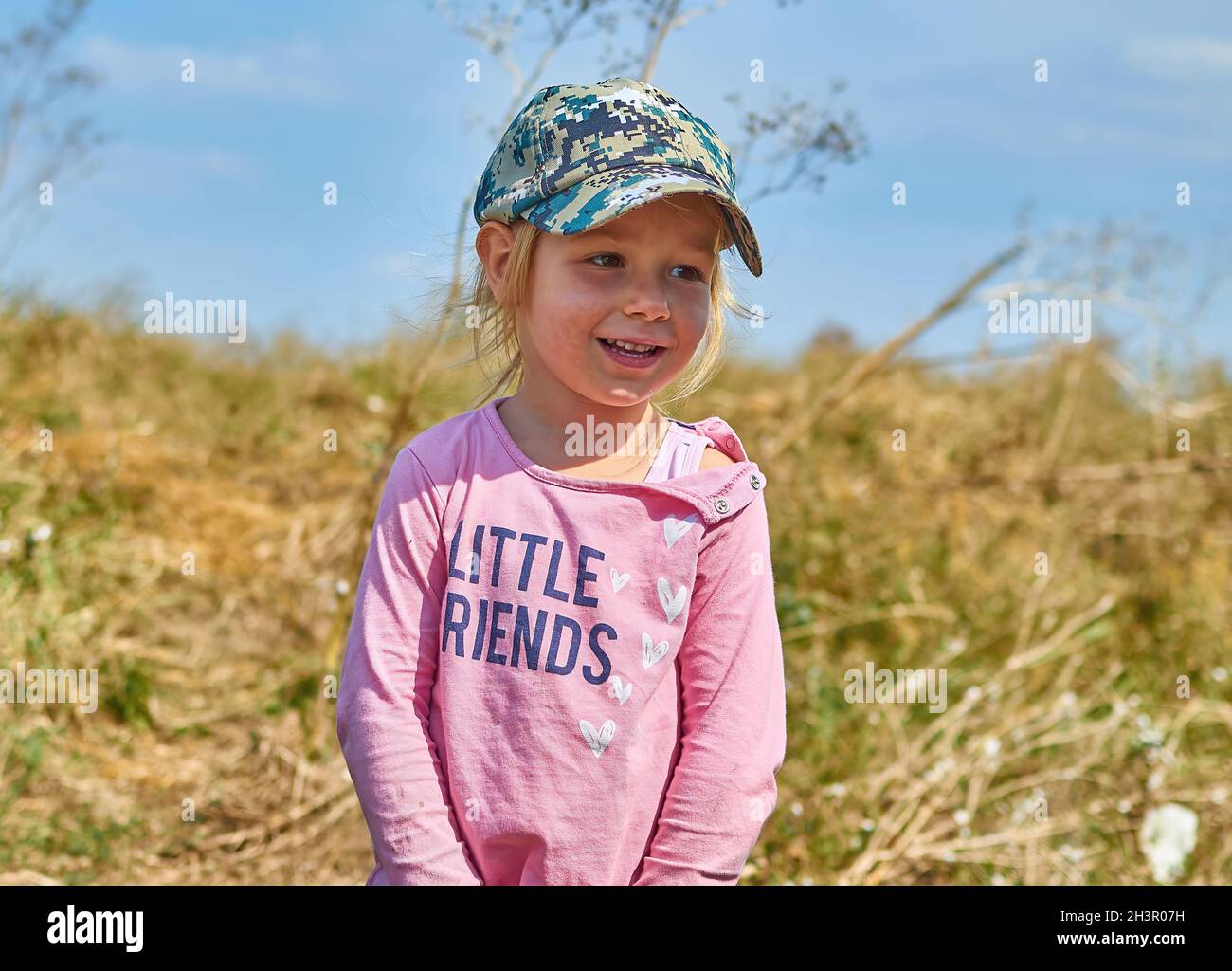 Kleines Mädchen tragen Hipster militärische Mütze im Freien Blick weg in der Wiese Stockfoto