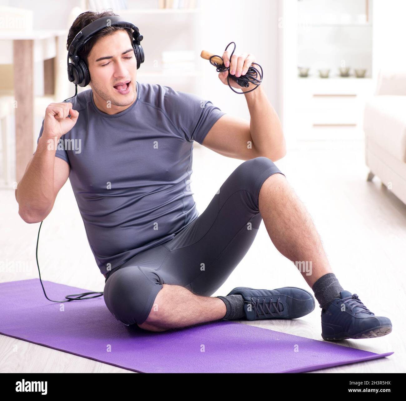 Mann Sport zu Hause und Hören von Musik Stockfoto