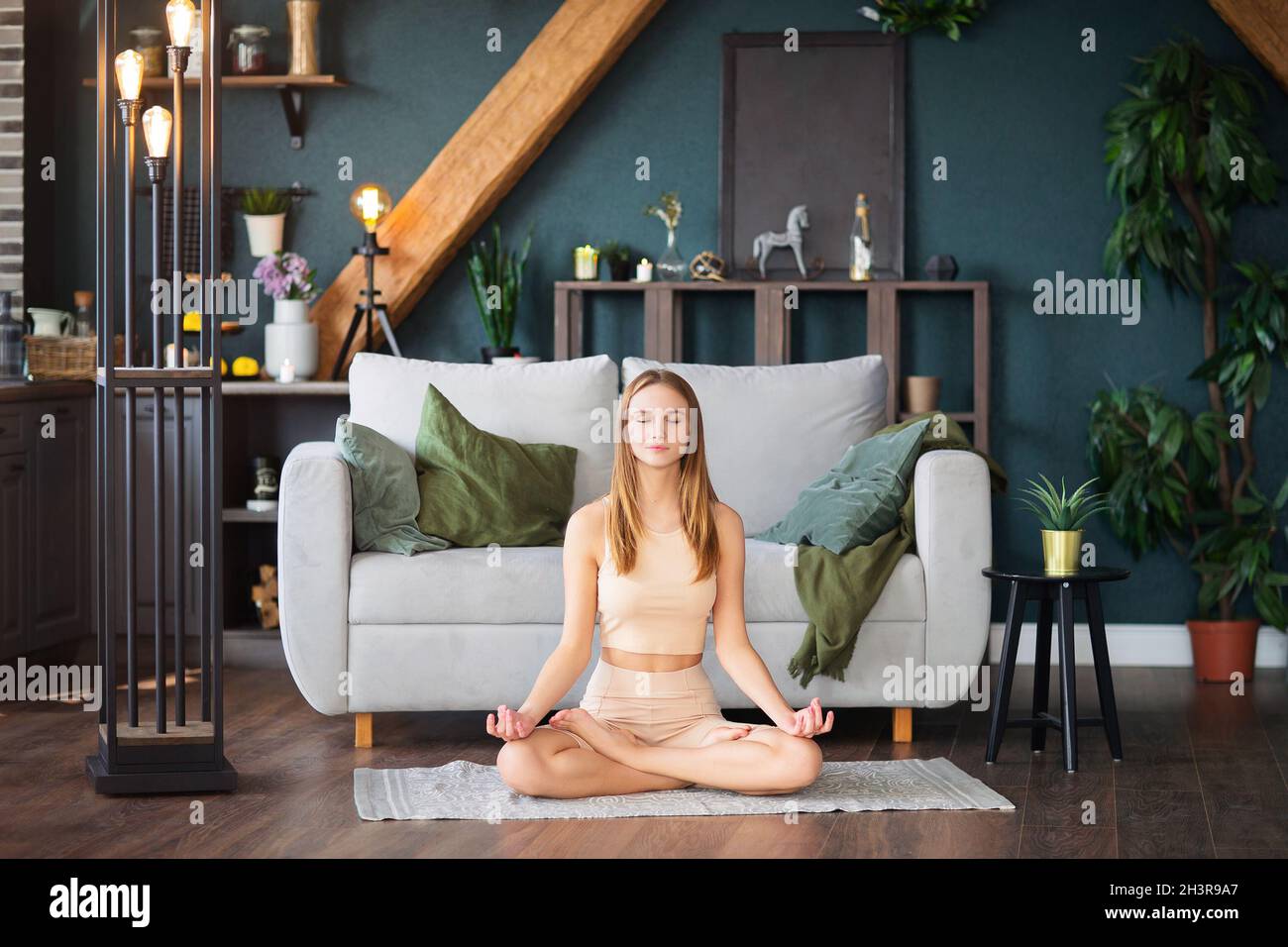 Junge Frau mit Online-Yoga-Sitzung zu Hause Stockfoto