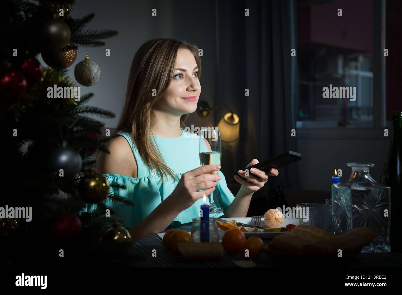 Frau, die in der Weihnachtsnacht alleine Fernsehen schaut Stockfoto