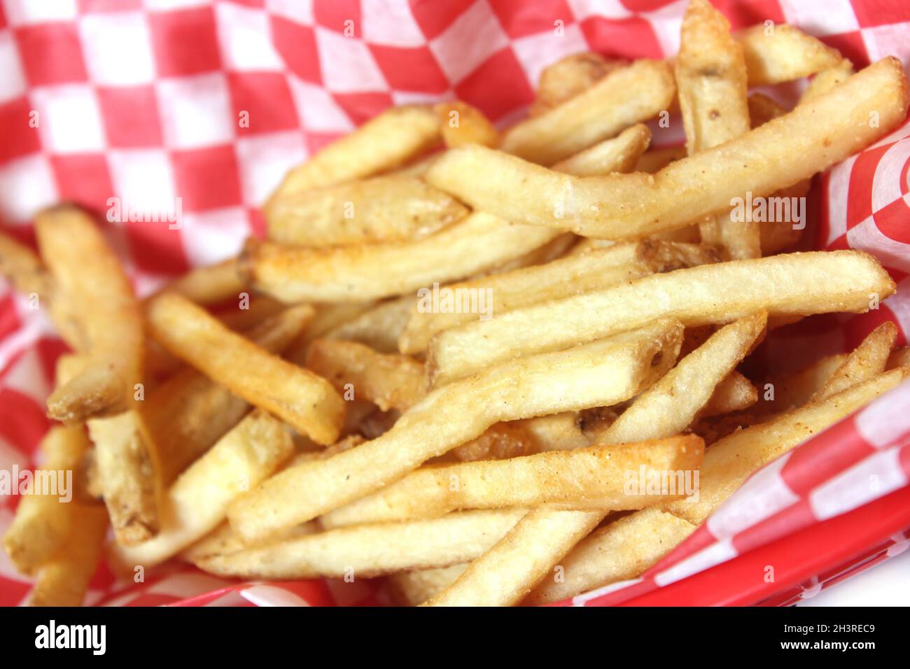 Pommes Frites im Retro Cafe mit kariertem Papier Stockfoto