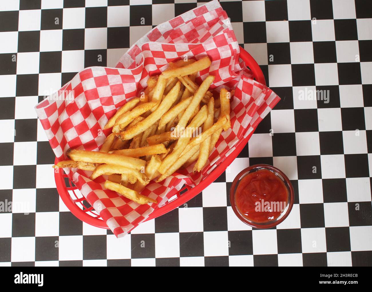 Pommes Frites im Retro Cafe mit kariertem Papier Stockfoto