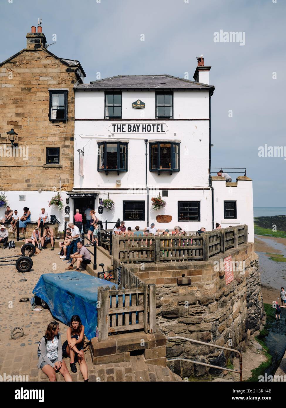 Das Bay Hotel und Besucher an einem geschäftigen Sommertag in Robin Hood's Bay im North York Moors National Park, Yorkshire England Stockfoto