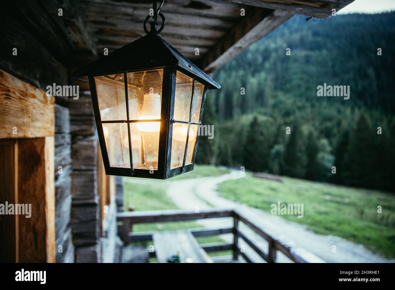 Laterne hängt auf der Veranda einer alten Holzhütte Stockfoto
