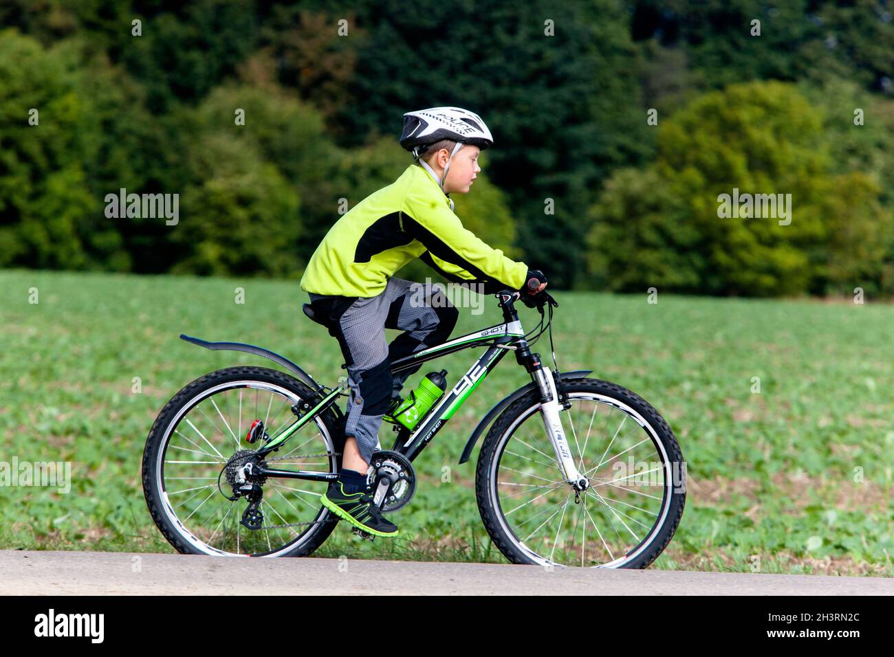 Kind Fahrrad im Helm reiten, Junge reiten biike, Seitenansicht Stockfoto