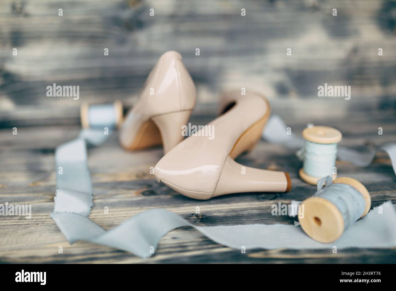 Blaue Seidenbänder auf Spulen mit beigen Schuhen der Braut. Stockfoto